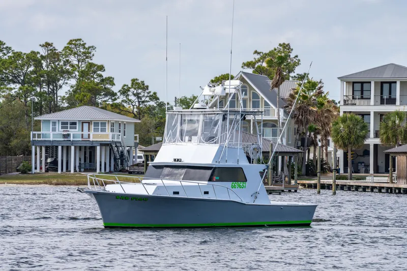Slide: The Image of 1983 Resmondo 38 boat on water near waterfront homes, clear sky background. - 7