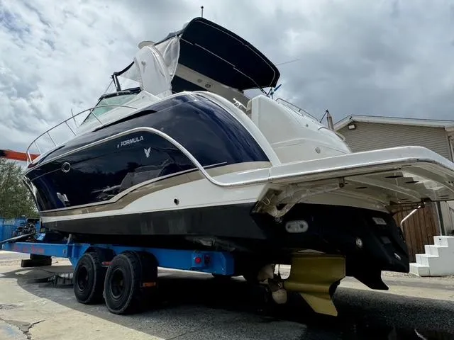 Slide: The Image of 2013 Formula 40pc boat on trailer, dark blue and white, under cloudy sky. - 11