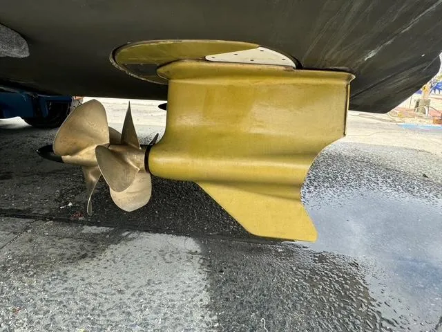 Slide: The Image of 2013 Formula 40pc boat propeller and rudder on a wet dock surface. - 12