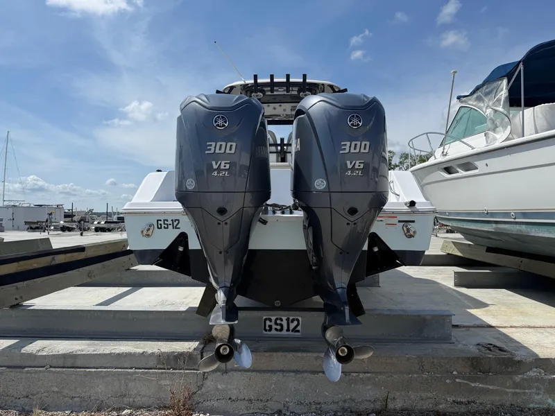 Slide: The Image of 2021 Sportsman Open 282 boat with twin Yamaha 300 V6 engines, docked under a clear sky. - 4
