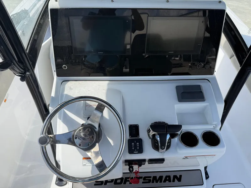 Slide: The Image of 2021 Sportsman Open 282 boat dashboard with steering wheel, dual screens, and control panel. - 9