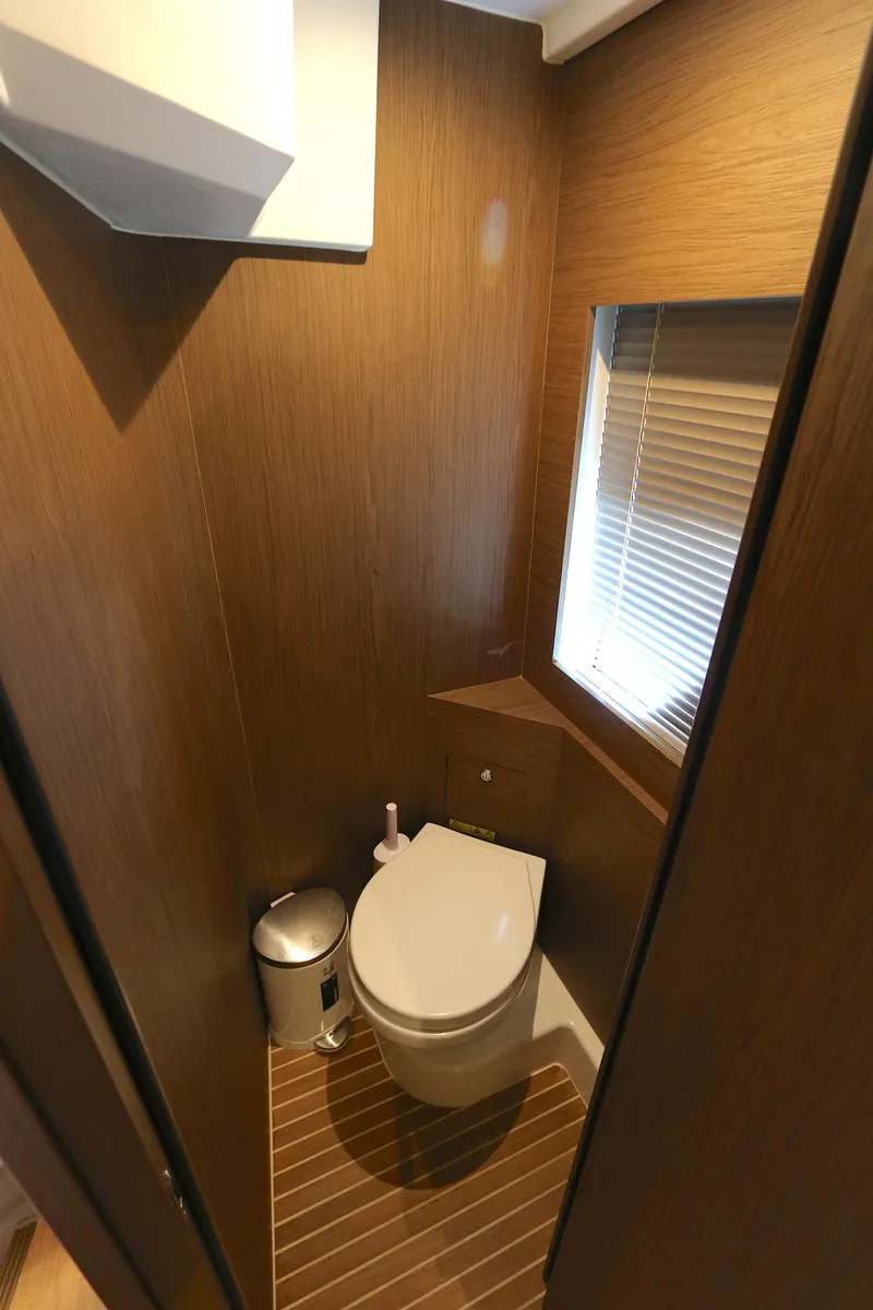 Slide: The Image of 2019 Beneteau Gran Turismo 50 yacht bathroom with modern wood paneling and compact design. - 10