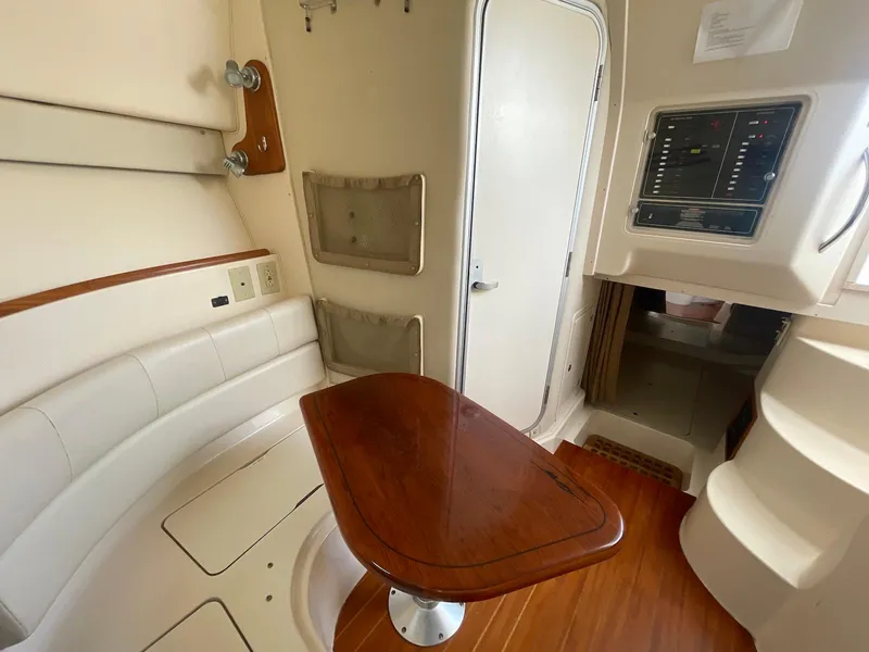 Slide: The Image of 2002 Grady-White Express 330 cabin interior with seating and wooden table. - 11