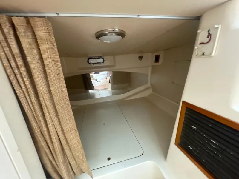 Slide: The Image of 2002 Grady-White Express 330 cabin interior with curtain and storage space. - 13