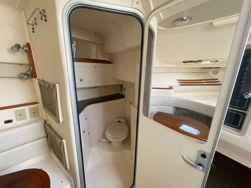 Slide: The Image of 2002 Grady-White Express 330 boat interior with compact bathroom and seating area. - 14