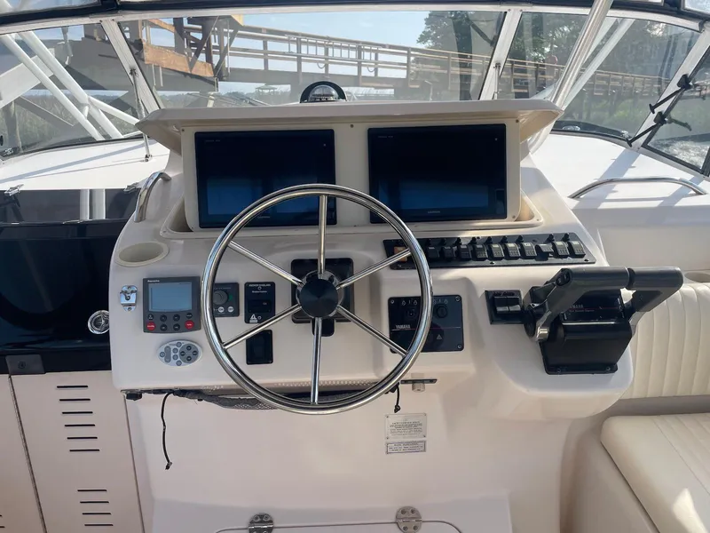 Slide: The Image of 2002 Grady-White Express 330 helm with dual screens and steering wheel. - 5
