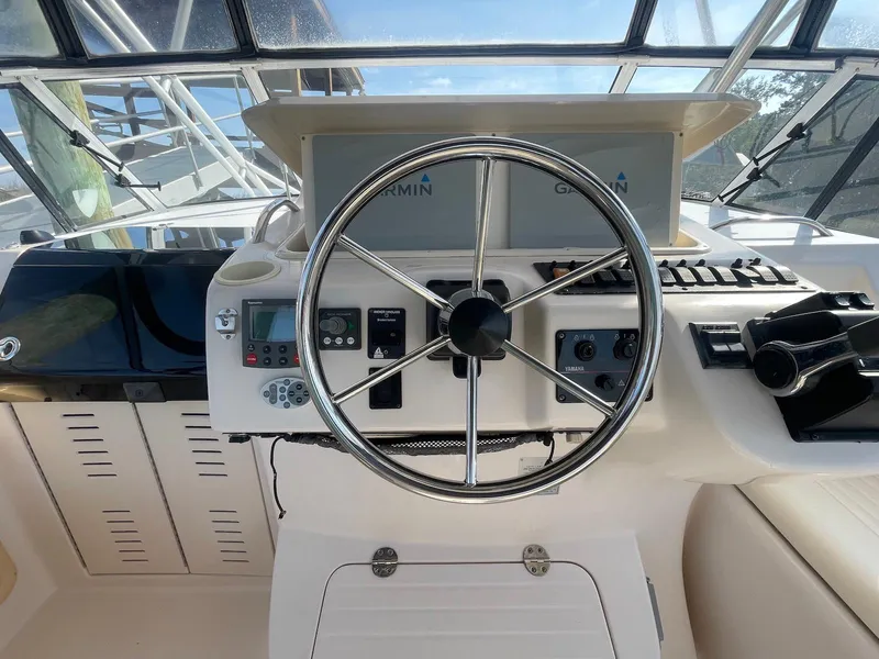 Slide: The Image of Helm of 2002 Grady-White Express 330 boat with steering wheel and navigation controls. - 7