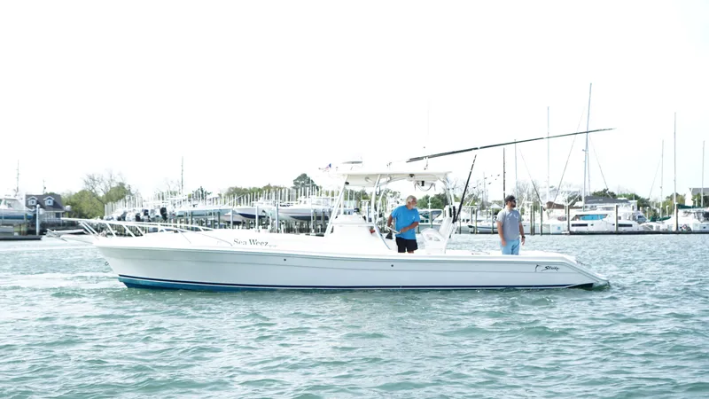 The Image of A 2016 Strike 35 boat on water with two people onboard, near a marina. - 1