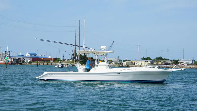 Slide: The Image of 2016 Strike 35 boat cruising on calm waters near a coastal town. - 3