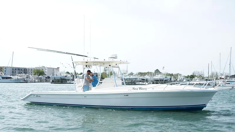 Slide: The Image of 2016 Strike 35 boat on water with people onboard, marina in background. - 6