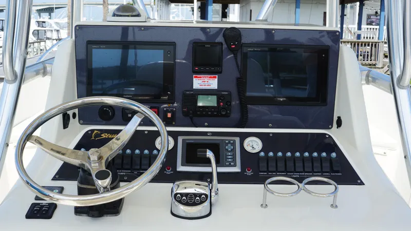 Slide: The Image of Control panel of a 2016 Strike 35 boat with steering wheel and navigation screens. - 7
