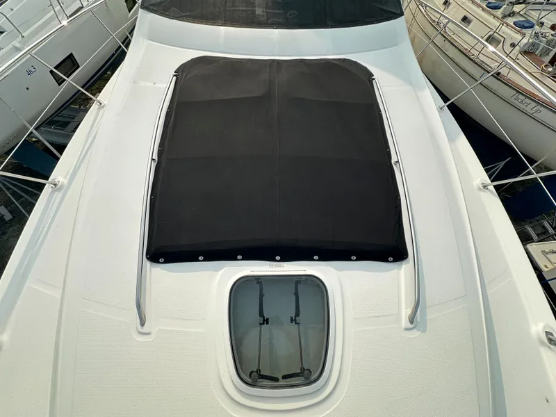 Slide: The Image of 2006 Sea Ray 58 Sedan Bridge yacht deck with black sunpad and hatch. - 18