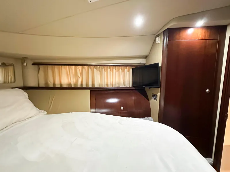 Slide: The Image of Interior cabin of 2006 Sea Ray 58 Sedan Bridge with bed, TV, and wooden accents. - 35