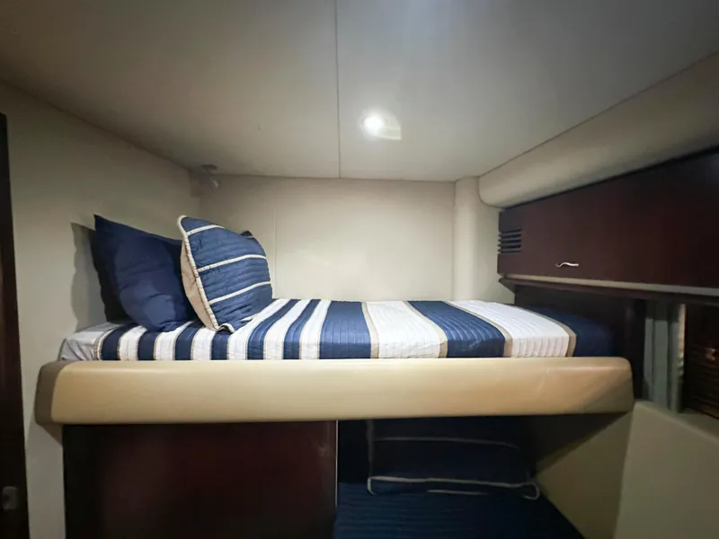 Slide: The Image of Cozy cabin interior of 2006 Sea Ray 58 Sedan Bridge with striped bedding. - 38