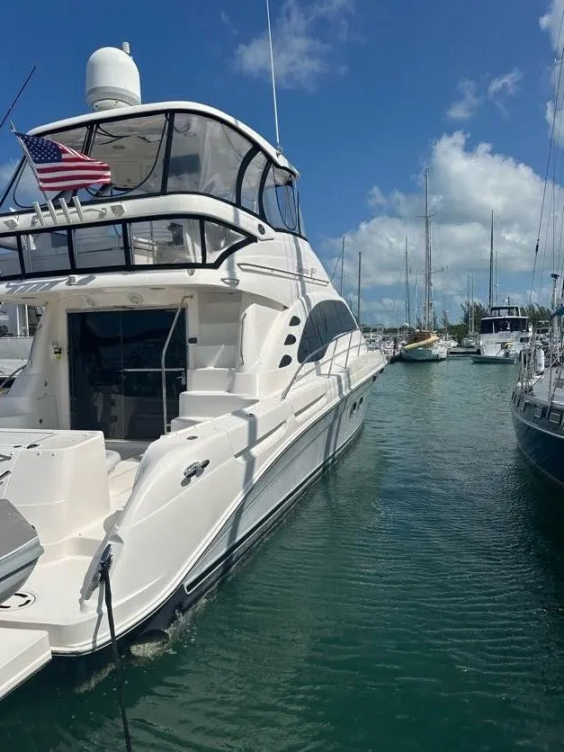Slide: The Image of 2006 Sea Ray 58 Sedan Bridge yacht docked in a marina under a clear blue sky. - 4