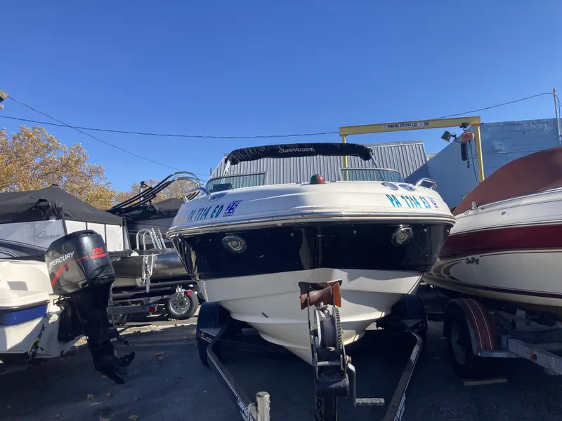 The Image of 2008 Chaparral 210 SSi boat on trailer, parked outdoors under clear blue sky. - 0