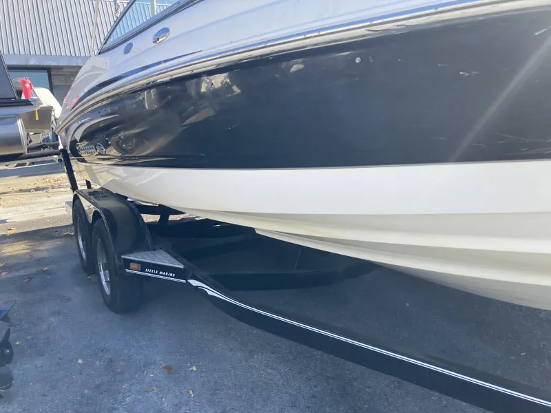 Slide: The Image of 2008 Chaparral 210 SSi boat on trailer, black and white hull, parked outdoors. - 3