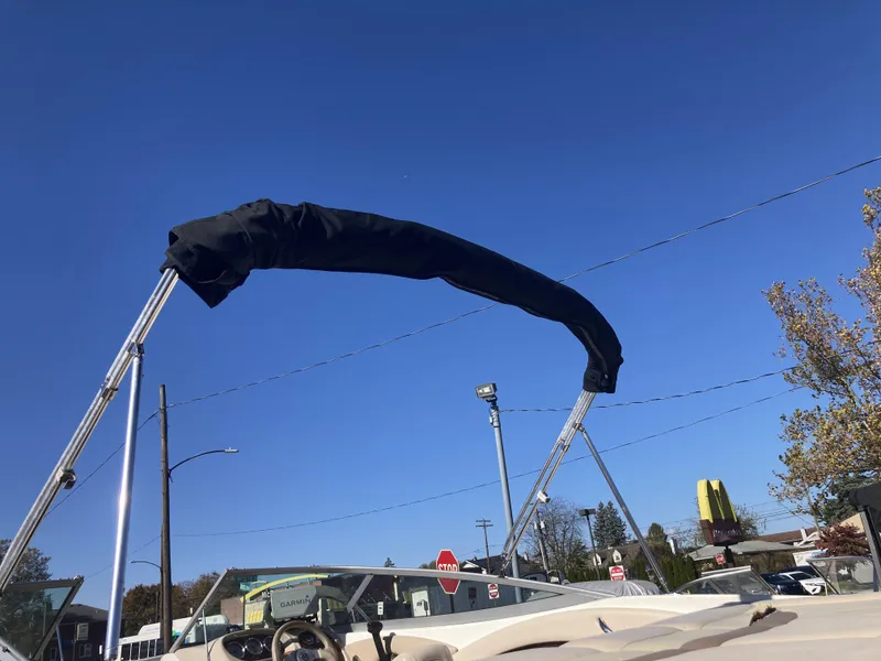 Slide: The Image of 2008 Chaparral 210 SSi boat with covered bimini top against clear blue sky. - 9