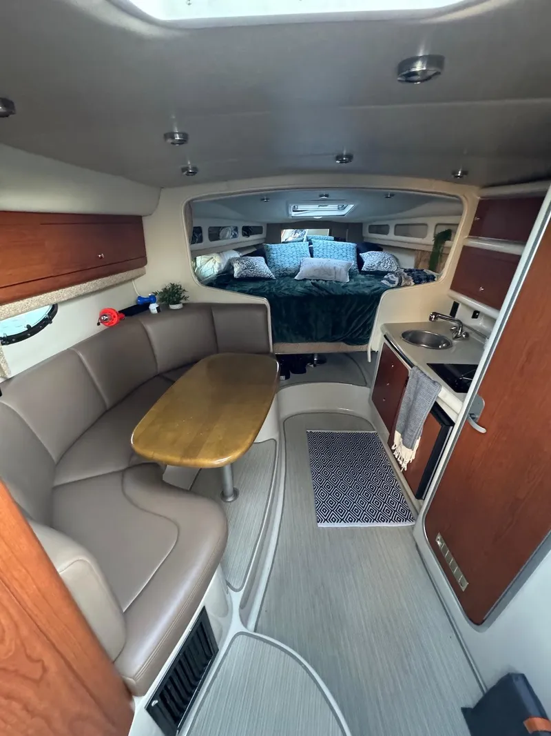 Slide: The Image of 2003 Chaparral Signature 280 cabin interior with seating, table, and kitchenette. - 10