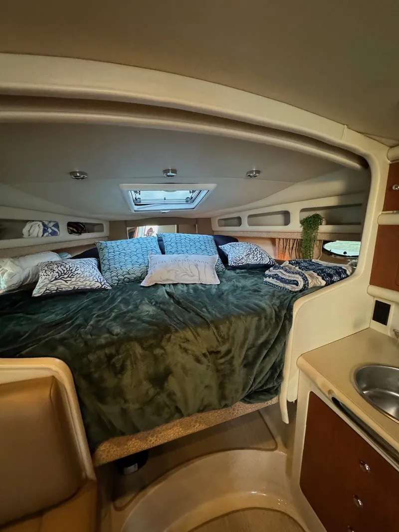 Slide: The Image of 2003 Chaparral Signature 280 cabin interior with cozy bed and compact kitchenette. - 13