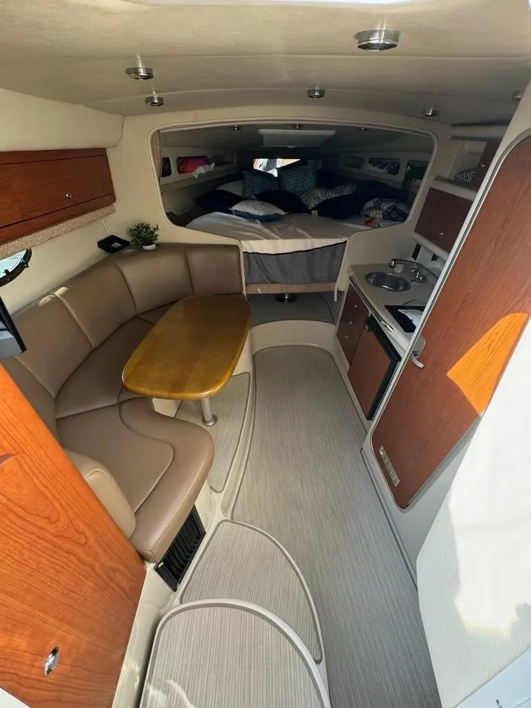 Slide: The Image of 2003 Chaparral Signature 280 cabin interior with seating, table, and kitchenette. - 18
