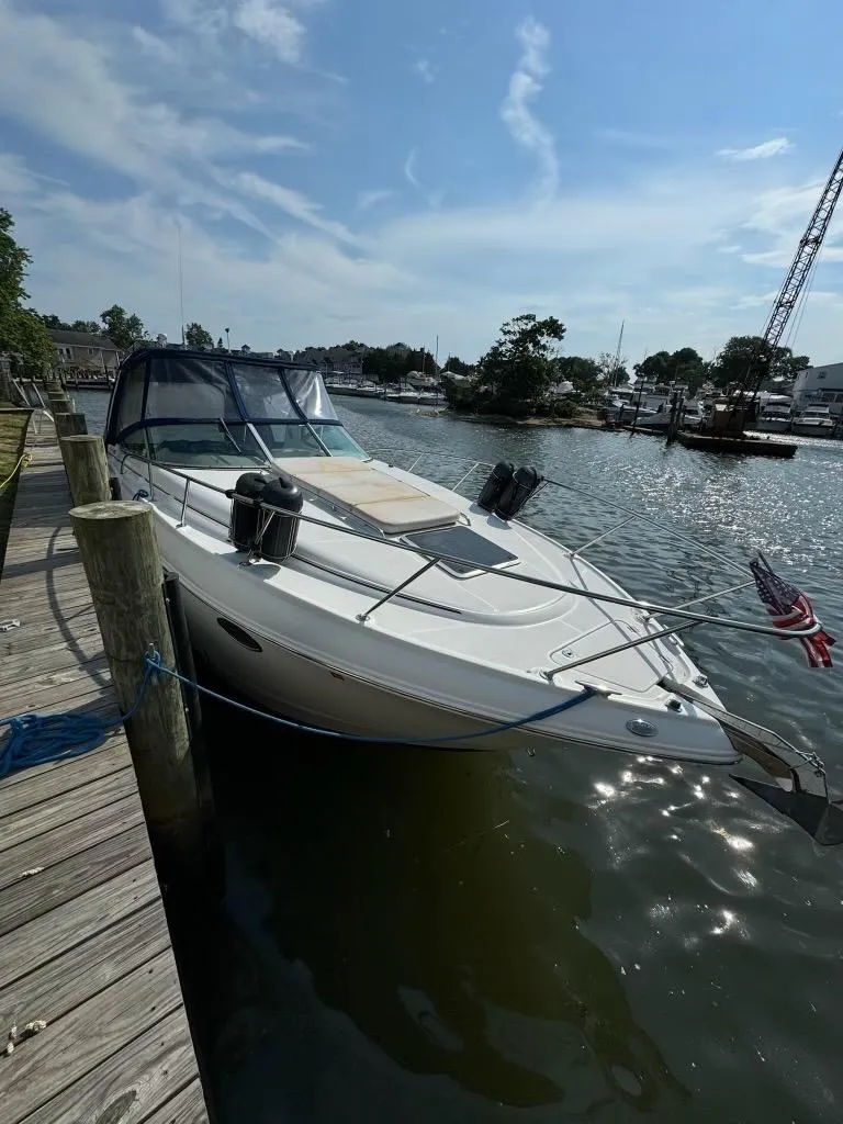 Slide: The Image of 2003 Chaparral Signature 280 boat docked by a wooden pier on a sunny day. - 2