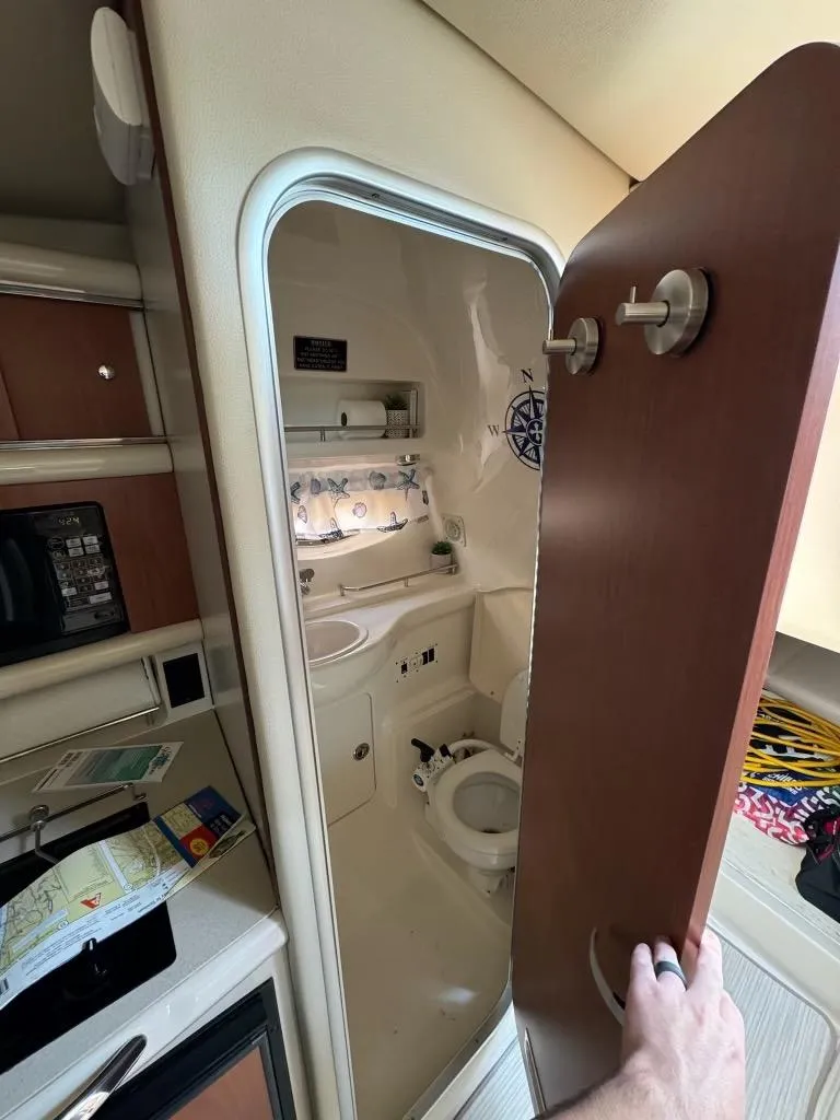 Slide: The Image of 2003 Chaparral Signature 280 boat interior with compact bathroom and kitchenette. - 23