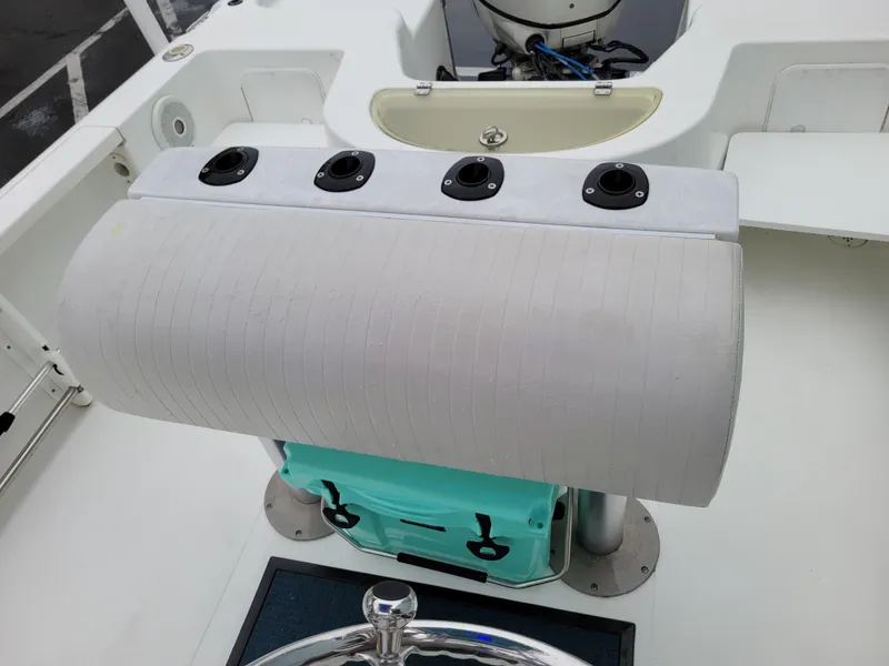 Slide: The Image of 2006 Sea Pro 196 Center Console boat interior with cushioned seating and rod holders. - 13