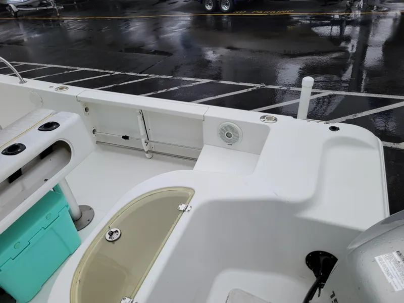 Slide: The Image of 2006 Sea Pro 196 Center Console boat interior with storage and seating on a wet dock. - 8
