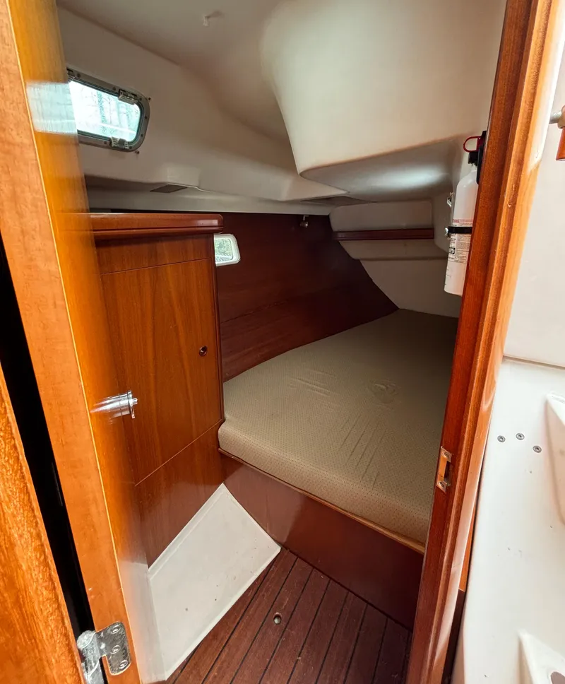 Slide: The Image of 2001 Beneteau 361 cabin interior with wooden finish and cozy sleeping area. - 13