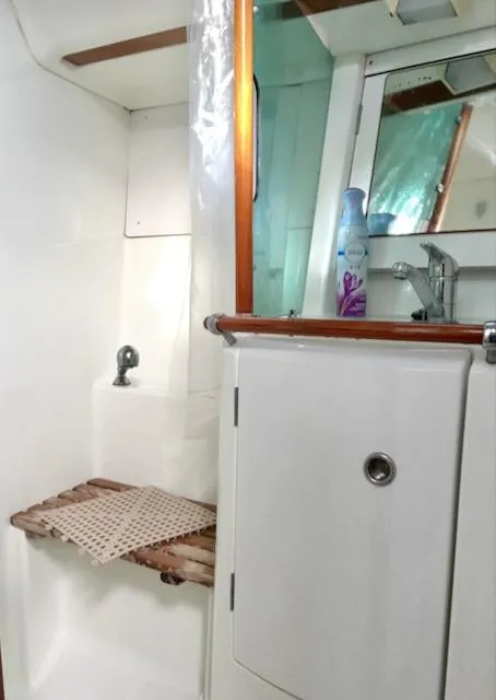 Slide: The Image of 2001 Beneteau 361 yacht bathroom with sink, mirror, and wooden accents. - 16