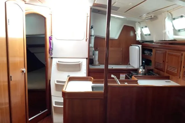 Slide: The Image of Interior of 2001 Beneteau 361 sailboat with wood finish and compact kitchen area. - 8