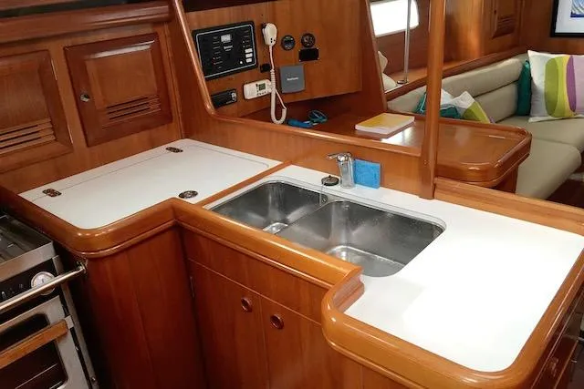 Slide: The Image of 2001 Beneteau 361 yacht interior with wooden cabinetry and dual sink in the galley. - 9