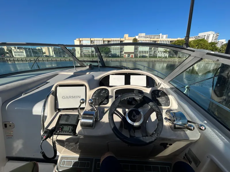 Slide: The Image of Helm of 2004 Sea Ray 340 Sundancer with Garmin navigation, docked by waterfront buildings. - 10