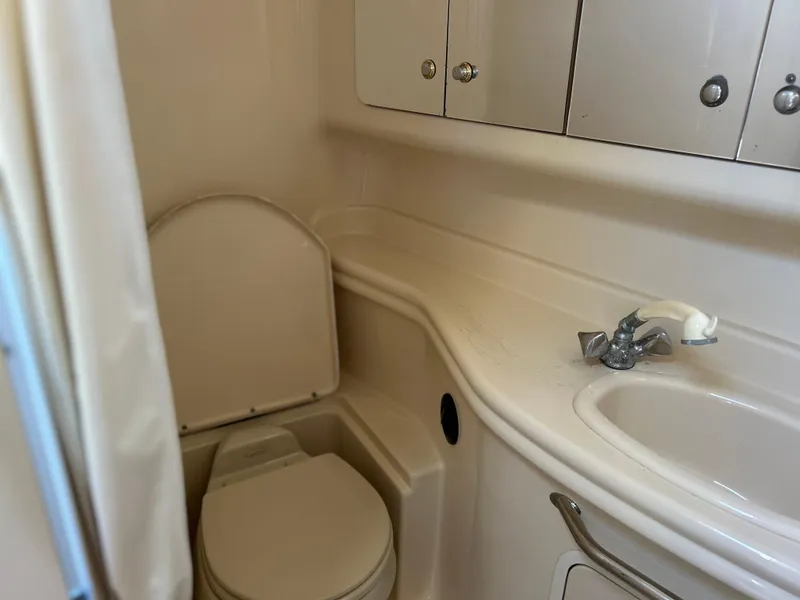 Slide: The Image of 2004 Sea Ray 340 Sundancer bathroom with toilet, sink, and storage cabinets. - 17