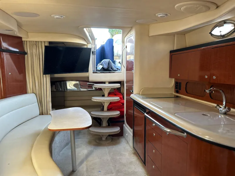 Slide: The Image of 2004 Sea Ray 340 Sundancer interior with kitchenette, seating, and TV. - 18