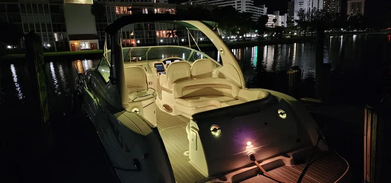 Slide: The Image of 2004 Sea Ray 340 Sundancer yacht illuminated at night, docked by waterfront buildings. - 27