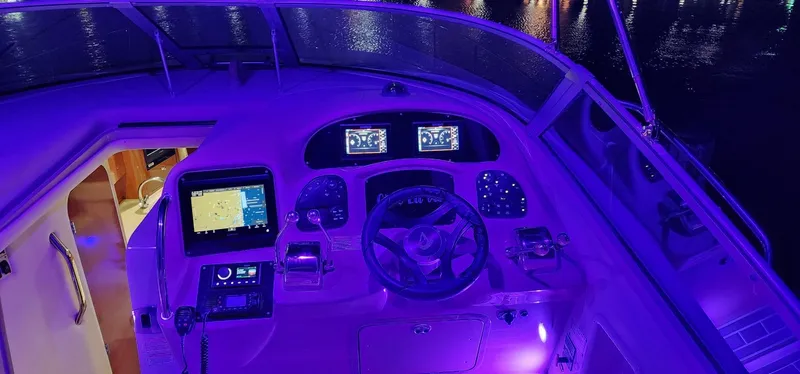 Slide: The Image of Cockpit of 2004 Sea Ray 340 Sundancer with illuminated controls and navigation screens at night. - 29
