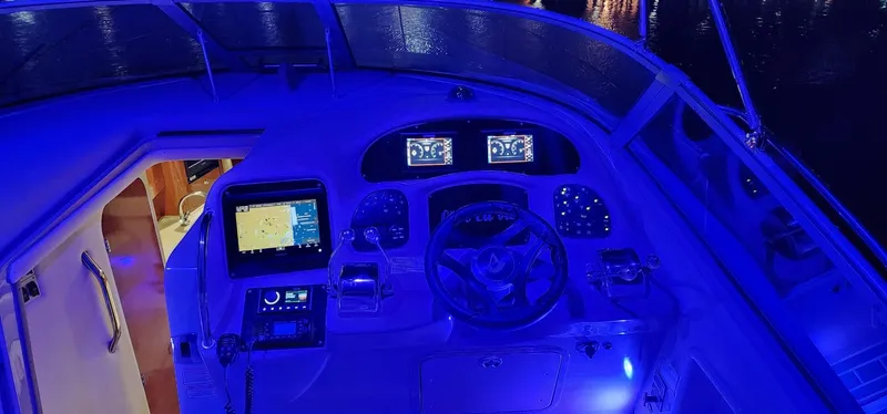 Slide: The Image of 2004 Sea Ray 340 Sundancer cockpit illuminated with blue LED lights at night. - 33