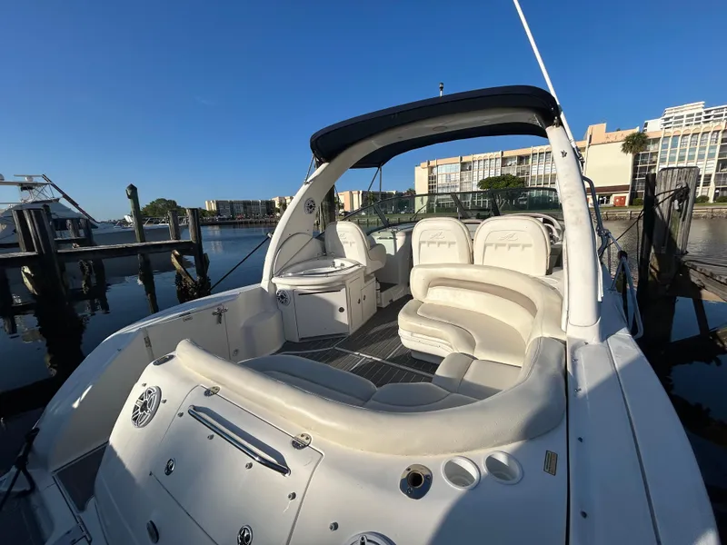 Slide: The Image of 2004 Sea Ray 340 Sundancer boat docked, featuring spacious seating and sleek design. - 9