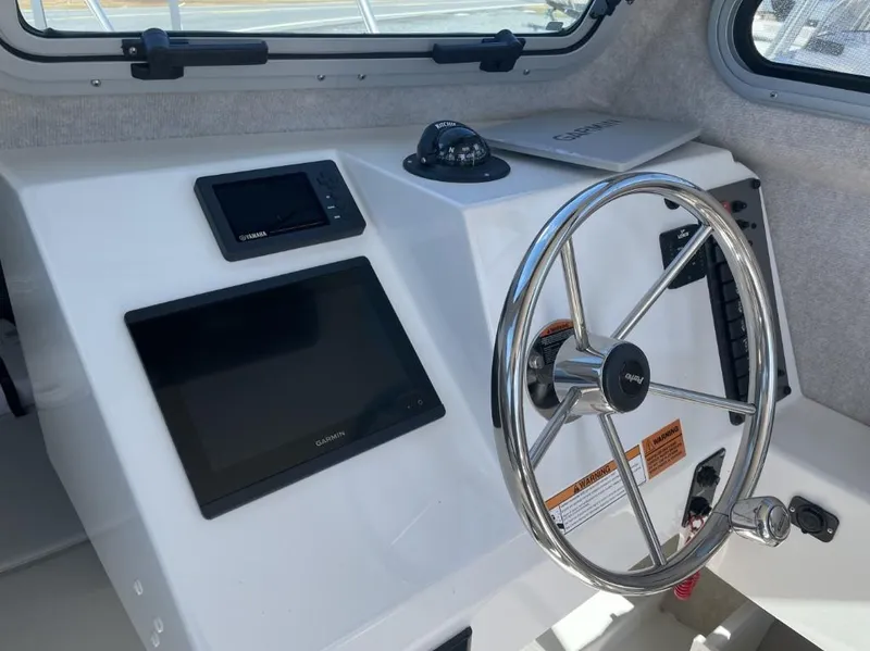Slide: The Image of 2022 Parker 2120 boat dashboard with steering wheel, Garmin and Yamaha displays. - 10
