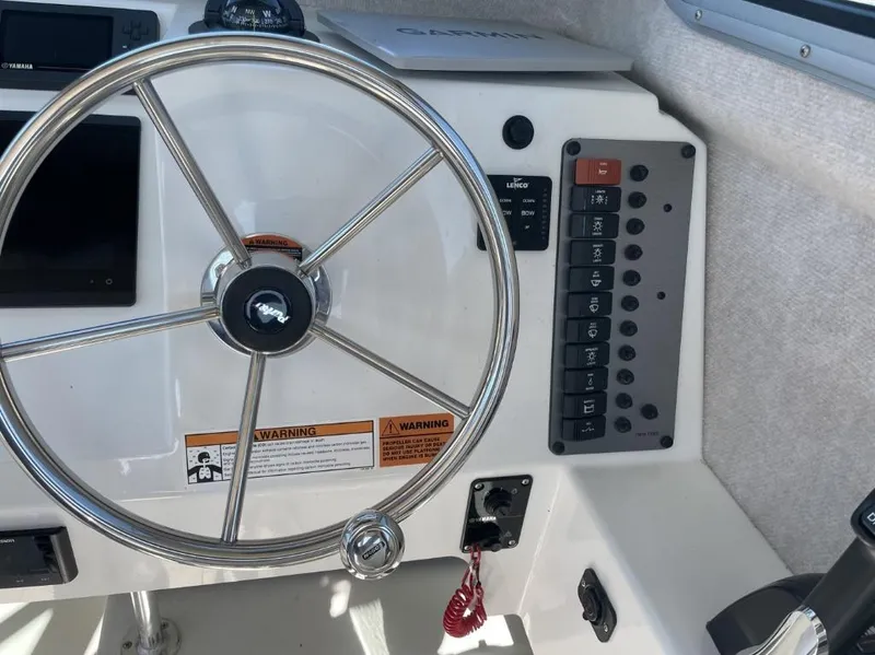Slide: The Image of Steering wheel and control panel of 2022 Parker 2120 boat cockpit. - 11