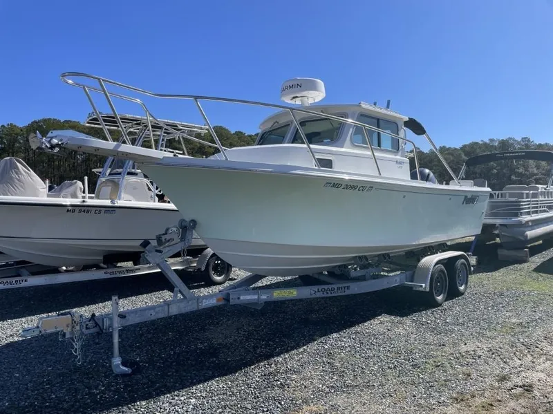 Slide: The Image of 2022 Parker 2120 boat on trailer, parked outdoors under clear blue sky. - 3