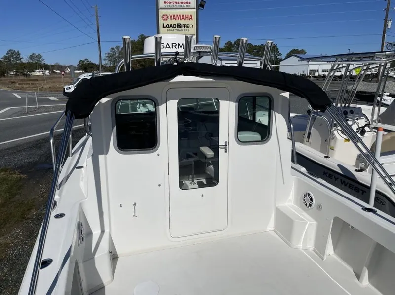 Slide: The Image of 2022 Parker 2120 boat with enclosed cabin, docked near road, clear sky. - 5