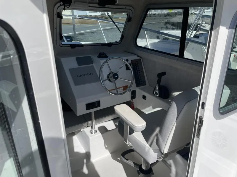 Slide: The Image of Interior of a 2022 Parker 2120 boat with steering wheel and Garmin navigation system. - 8