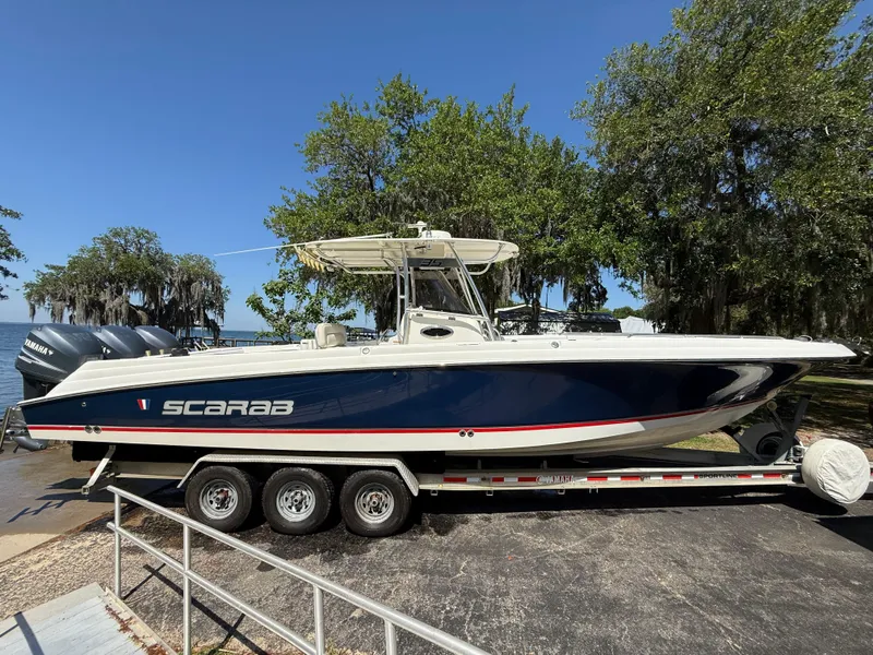 Slide: The Image of 2007 Wellcraft 352 Tournament boat on trailer, blue hull, triple engines, parked outdoors. - 8
