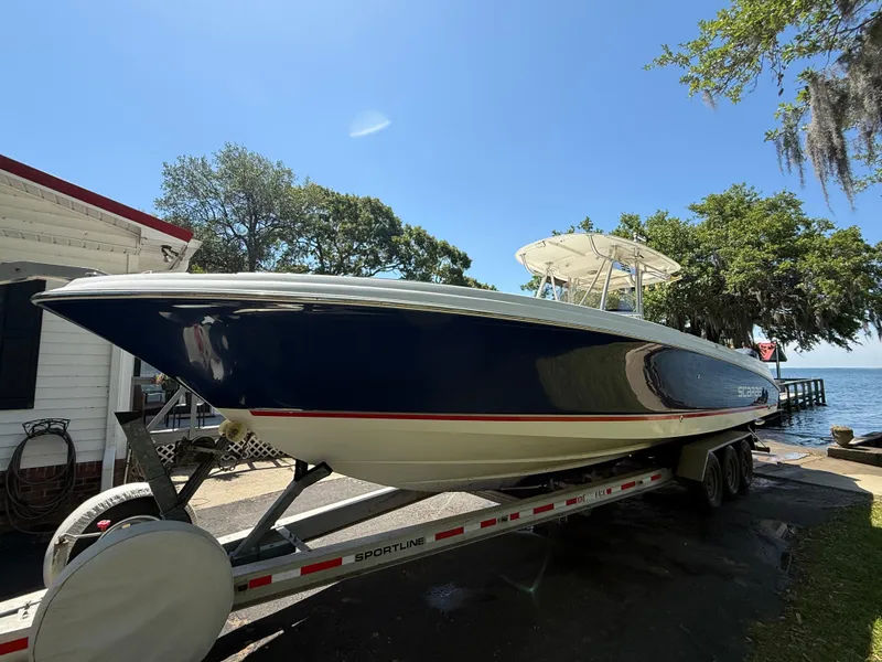 Slide: The Image of 2007 Wellcraft 352 Tournament boat on trailer, parked near a lakeside under clear blue sky. - 9