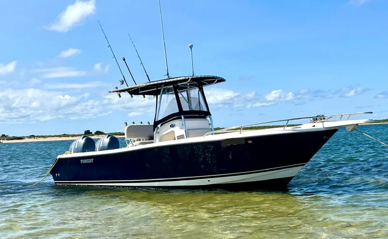 Slide: The Image of 2008 Pursuit C 250 Center Console boat anchored in clear, shallow water under a blue sky. - 0