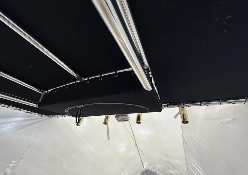 Slide: The Image of 2008 Pursuit C 250 Center Console boat canopy with metal supports and rod holders. - 23