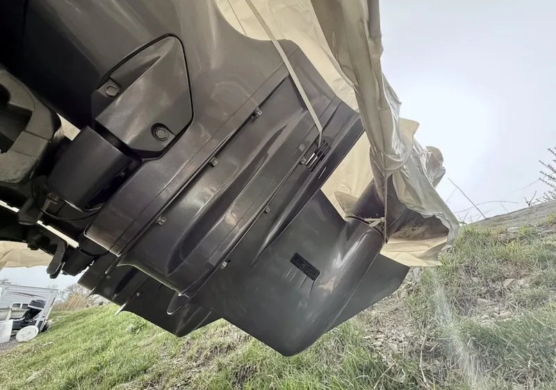 Slide: The Image of 2008 Pursuit C 250 Center Console boat engine under cover, on grassy area. - 27